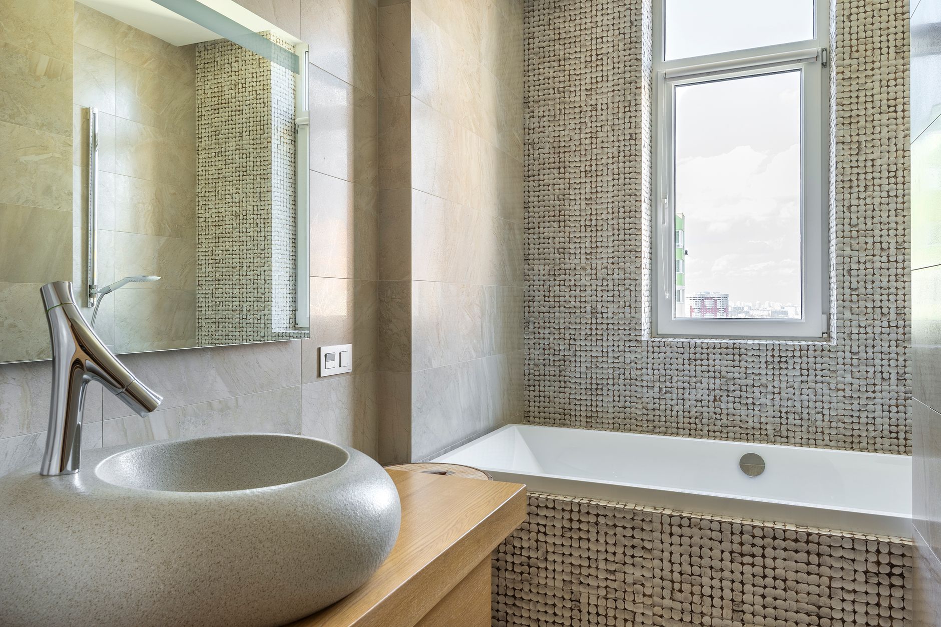 Elegant bathroom featuring a stone sink, modern faucet, and stylish bathtub with mosaic tiles in Riverside, CA